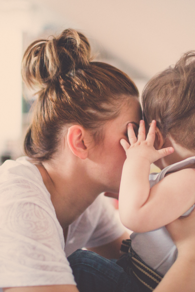 Baby and mum with their heads together in what are the challenges of motherhood post